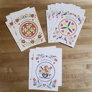 May include: Greeting cards with matching envelopes. Each card features a colorful, circular design with floral and bird motifs. The cards have messages such as "Have a Happy Day", "Bless Our Friendship", and "Good Wishes to You".