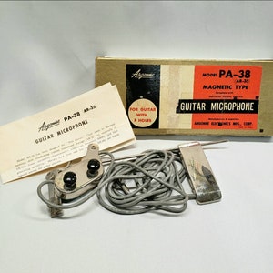 May include: Vintage Argonne PA-38 guitar microphone with original packaging and documentation. The box is tan with red and black text. The microphone is silver with a gray cable and includes a mounting bracket. The text on the box reads "Guitar Microphone".
