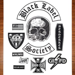 May include: A collection of black and white embroidered patches featuring the Black Label Society logo, a skull with a brain diagram, a coffin-shaped patch with the word BERSERKER, a cross with DOOM CREW INC, and various text-based rectangular patches.