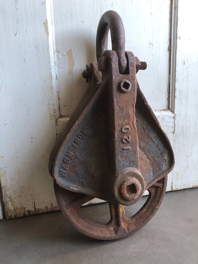 May include: A rusty cast iron pulley with a yellow painted wheel and the text "WASH IRON CO. 120" on the side.