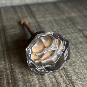 May include: A rustic wooden sign with the text "Welcome" in a handwritten style. The sign is painted white with a distressed finish, and features a decorative floral element. The background is a blurred image of a home.