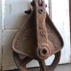May include: A rusty cast iron pulley with a wheel and a hook. The pulley is labeled "WASH. IRON" and "220".