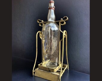 1960’s Martin's VVO Scotch Whisky Bottle and Wrought Iron Pouring Cradle, James Martin & Co Ltd, 1 Gallon Bottle and Tilting Metal Stand