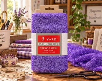 May include: A roll of purple sparkle mesh fabric with a label reading 3 YARD FABRIC CUT SPARKLE MESH 108 x 59 IN 274.3 x 150 CM. The mesh has a textured, fibrous appearance and is displayed upright with a portion of the fabric draped to the side.