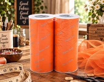 May include: Two connected rolls of bright orange matte tulle fabric. The surface of the tulle features a repeating, subtle watermark pattern of the text "Matte Tulle" printed in a light gray color across the vibrant orange mesh material.