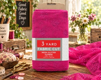 May include: A folded bolt of vibrant hot pink mesh fabric featuring a glittery floral pattern. A white and red label on the front reads 3 YARD FABRIC CUT, MESH GLITTER FLOWER, 108 x 55 IN, 274.3 x 140 CM. The fabric has a sheer, textured appearance.