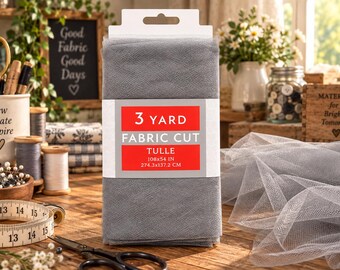 May include: A folded piece of grey tulle fabric with a white and red label that reads 3 YARD FABRIC CUT TULLE 108x54 IN 274.3x137.2 CM. The fabric is presented in a rectangular shape with a hanging tab at the top, showcasing a fine mesh texture.