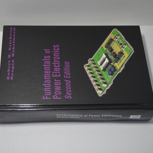 May include: A black book with the title "Fundamentals of Power Electronics, Second Edition" on the cover. The cover also features a green circuit board with electronic components.
