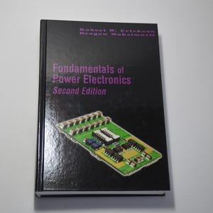 May include: A black book with a purple title that reads "Fundamentals of Power Electronics, Second Edition". The authors are Robert W. Erickson and Dragan Maksimovic. The cover features a close-up of a circuit board.