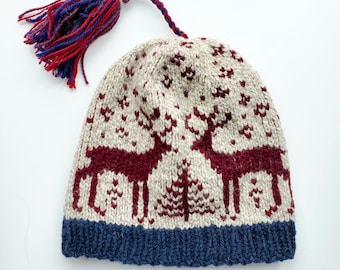 May include: A knitted hat with a burgundy and white reindeer pattern and a blue brim. The hat has a long tassel with red and purple yarn.
