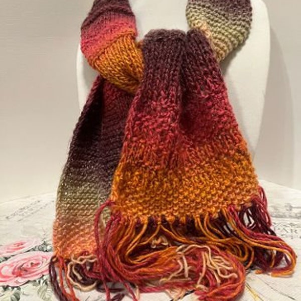 Hand knitted scarf in variegated yarn; tan, light orange, pink, brown, gold.  60" long, including 4" of fringe. Machine washable, very soft