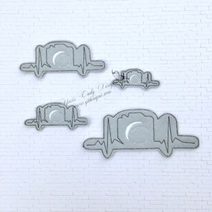 May include: Four gray embroidered patches with a camera and a heartbeat design. The camera has a crescent moon inside. The patches are on a white brick wall background.