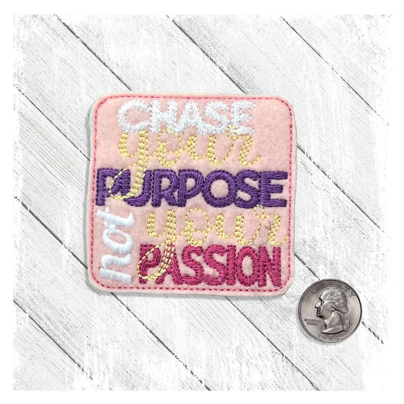 May include: Pink felt patch with the words "Chase Your Purpose, Your Passion" embroidered in white, yellow, purple, and pink thread.