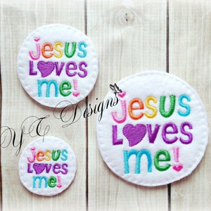 Puede incluir: Tres círculos de fieltro blanco con el texto "¡Jesús me ama!" en colores arcoíris y un corazón morado. Los círculos son de diferentes tamaños.