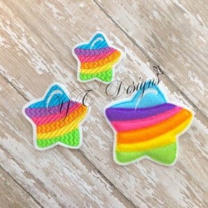 May include: Three rainbow star-shaped embroidered patches with a white outline. The stars are layered on top of each other, with the largest star at the bottom and the smallest star at the top. The stars are made of a variety of colors, including red, orange, yellow, green, blue, and purple.