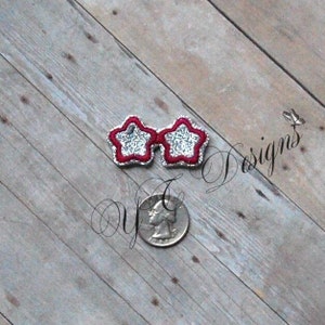 May include: Star-shaped sunglasses with a red outline and silver glitter filling. The glasses are connected by a red bridge. A quarter is next to the glasses. The background is a wooden surface.
