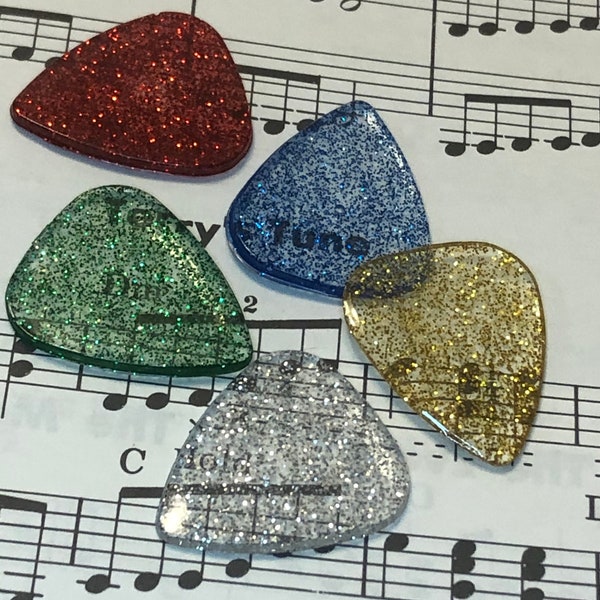 set of 5 Christmas colored glitter guitar picks in clear resin; red, gold, blue, gold, green and silver