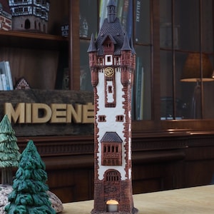 May include: A ceramic tower with a red brick base and white walls. The tower has a black roof and a clock face with Roman numerals. The tower is lit by a candle inside.