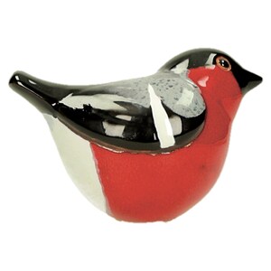 May include: A ceramic bird figurine with black, white, and red paint. The bird has a round body and a short beak.