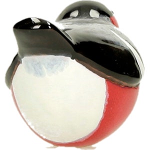 May include: A ceramic robin figurine with a black head and wings, a white belly, and a red breast. The robin is facing away from the camera and is perched on a white surface.