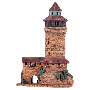May include: A small, hand-crafted ceramic tower with a brown roof and stone walls. The tower has a small arched doorway and is decorated with green vines and red flowers.