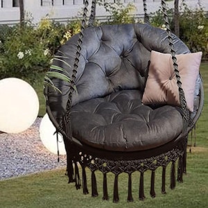 Macrame hanging chair with butterfly pattern on the back, graphite color, with large pillows to match.