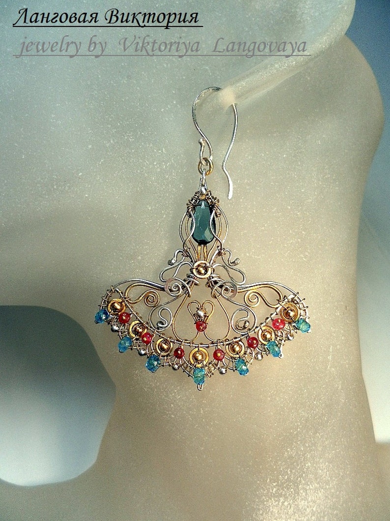 May include: Silver and gold filigree earrings with a teal gemstone and red and blue beads.