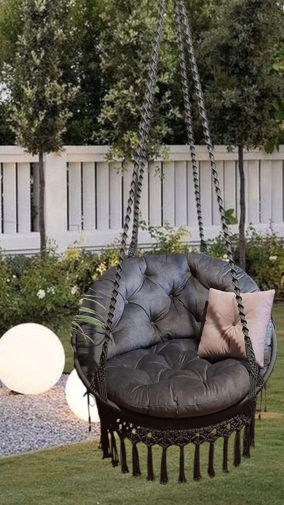 Macrame hanging chair with butterfly pattern on the back, graphite color, with large pillows to match.