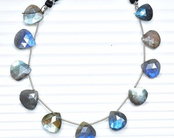 May include: A strand of iridescent blue labradorite gemstone beads in a pear shape. The beads are strung on a silver wire and have a tassel at each end.