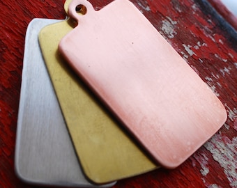 May include: Three rectangular metal tags in silver, gold, and copper. The tags are stacked on top of each other, with the copper tag on top.
