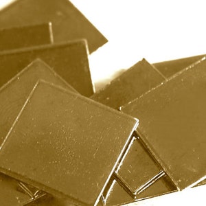 May include: A stack of gold-colored metal squares, likely for crafting or decorative purposes.