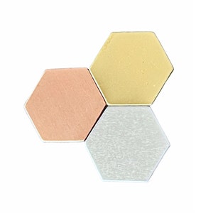 May include: Three hexagonal tiles in different colors: gold, copper, and silver. The tiles are arranged in a staggered pattern.