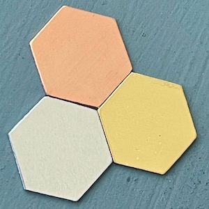 May include: Three hexagonal tiles in different colors: peach, yellow, and white. The tiles are arranged in a triangular shape.