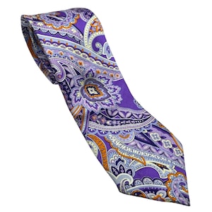 Könnte beinhalten: Eine Krawatte mit einer leuchtend violetten Grundfarbe und einem komplizierten Paisley-Muster in Hellblau, Weiß und Orange. Das Design besteht aus wirbelnden Blumenmotiven und dekorativen Bordüren, die sich auf dem Stoff wiederholen.