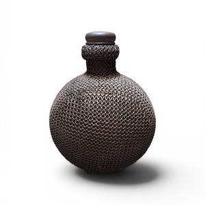Peut inclure: Une bouteille ronde décorative avec un extérieur sombre en forme de cotte de mailles. Elle présente un petit col et un bouchon plat et circulaire. La couleur générale est un marron foncé métallique. La bouteille est probablement en métal et a une surface texturée unique.