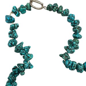 Puede incluir: Un collar compuesto por cuentas de turquesa irregulares y pulidas que presentan vetas de matriz negra. Las cuentas est&aacute;n ensartadas en un cord&oacute;n y aseguradas con un cierre de palanca de metal plateado que consiste en un anillo y una barra en T.