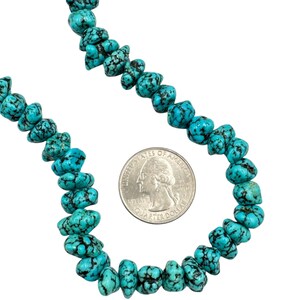 Puede incluir: Un collar de cuentas de turquesa irregulares y pulidas con tonos azul verdosos vibrantes y vetas oscuras. Las cuentas est&aacute;n dispuestas en forma curva junto a una moneda de 25 centavos de d&oacute;lar estadounidense de 2,43 cm de di&aacute;metro.