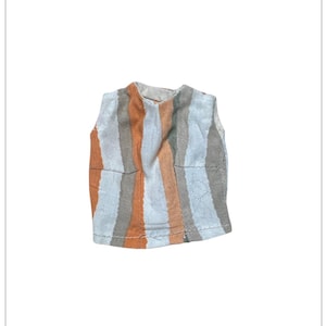 May include: A sleeveless top with vertical stripes in shades of orange, gray, and light blue. The fabric appears to be textured, and the top has a simple, round neckline. The garment is likely handmade.