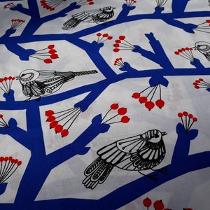 Puede incluir: Tela blanca con un patrón repetitivo azul y negro de pájaros estilizados posados en ramas con bayas rojas.