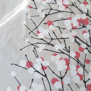 Puede incluir: Una tela blanca con un patr&oacute;n floral negro y rosa. El patr&oacute;n presenta ramas estilizadas con c&iacute;rculos blancos y rosas.