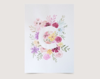 Può includere: Dipinto ad acquerello della lettera C circondata da fiori rosa, viola, gialli e bianchi.