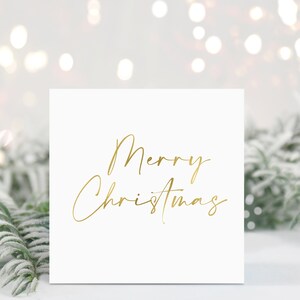 May include: A white card with the words "Merry Christmas" written in gold script.