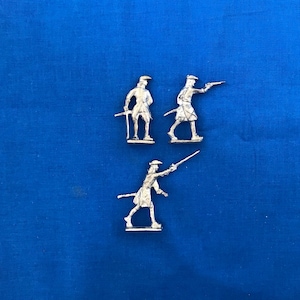 May include: Three silver toy soldiers, two standing and one in a fighting pose, on a blue background.