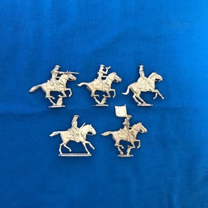 May include: Five miniature toy cavalry figures on horseback, painted in silver, with one figure holding a flag. The figures are posed in a galloping position, with their horses' legs raised in mid-air.
