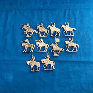 May include: A collection of twelve silver toy cavalry figures on horseback. The figures are posed in various riding positions, some holding swords and others holding flags.