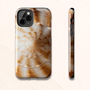 May include: A phone case with a seashell design in brown and white. The case has a glossy finish and a black border. The side view shows the case's thickness and button placement. The design is reminiscent of a spiral pattern.
