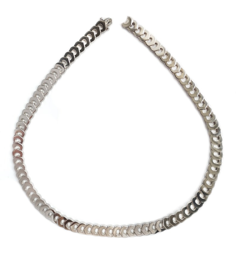 May include: A silver chain necklace with a curb link design