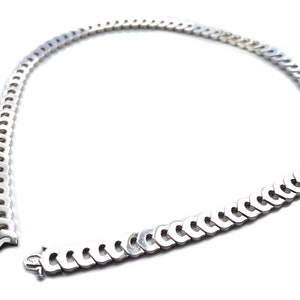May include: A silver chain necklace with a curb link design. The chain is open and the ends are visible.