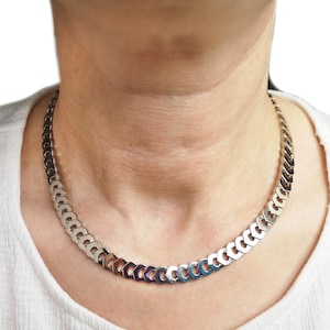May include: A silver chain necklace with a curb link design.