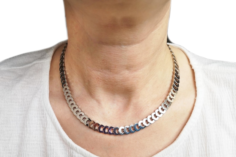 May include: A silver chain necklace with a curb link design.